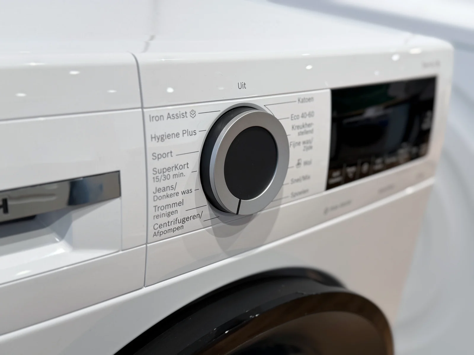 Detail van de programmaknop van de Bosch WGG244ZONL Iron Assist, met onder meer Iron Assist, Hygiëne Plus en Trommel reinigen.