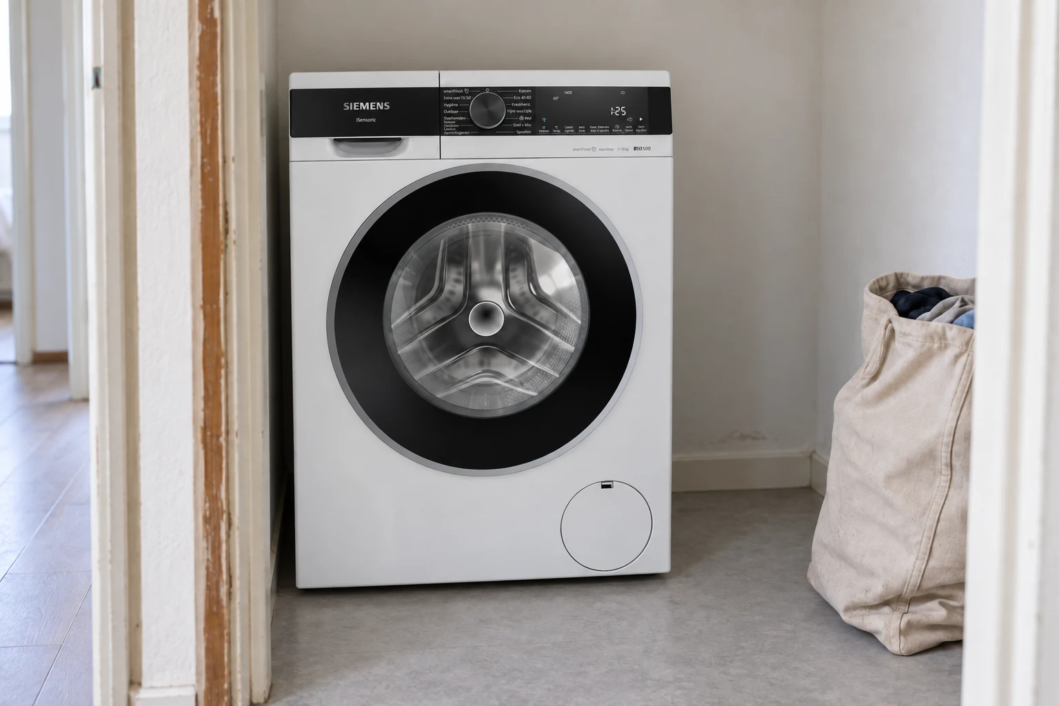 Witte Siemens-wasmachine in een wasnis naast de gang