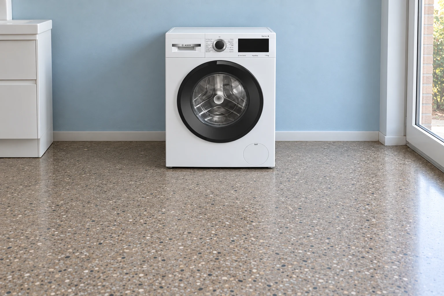 Witte wasmachine in een bijkeuken met vrije vloer ervoor