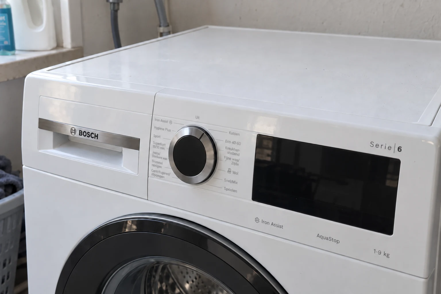 Schuine blik op de draaiknop en het donkere display van een wasmachine
