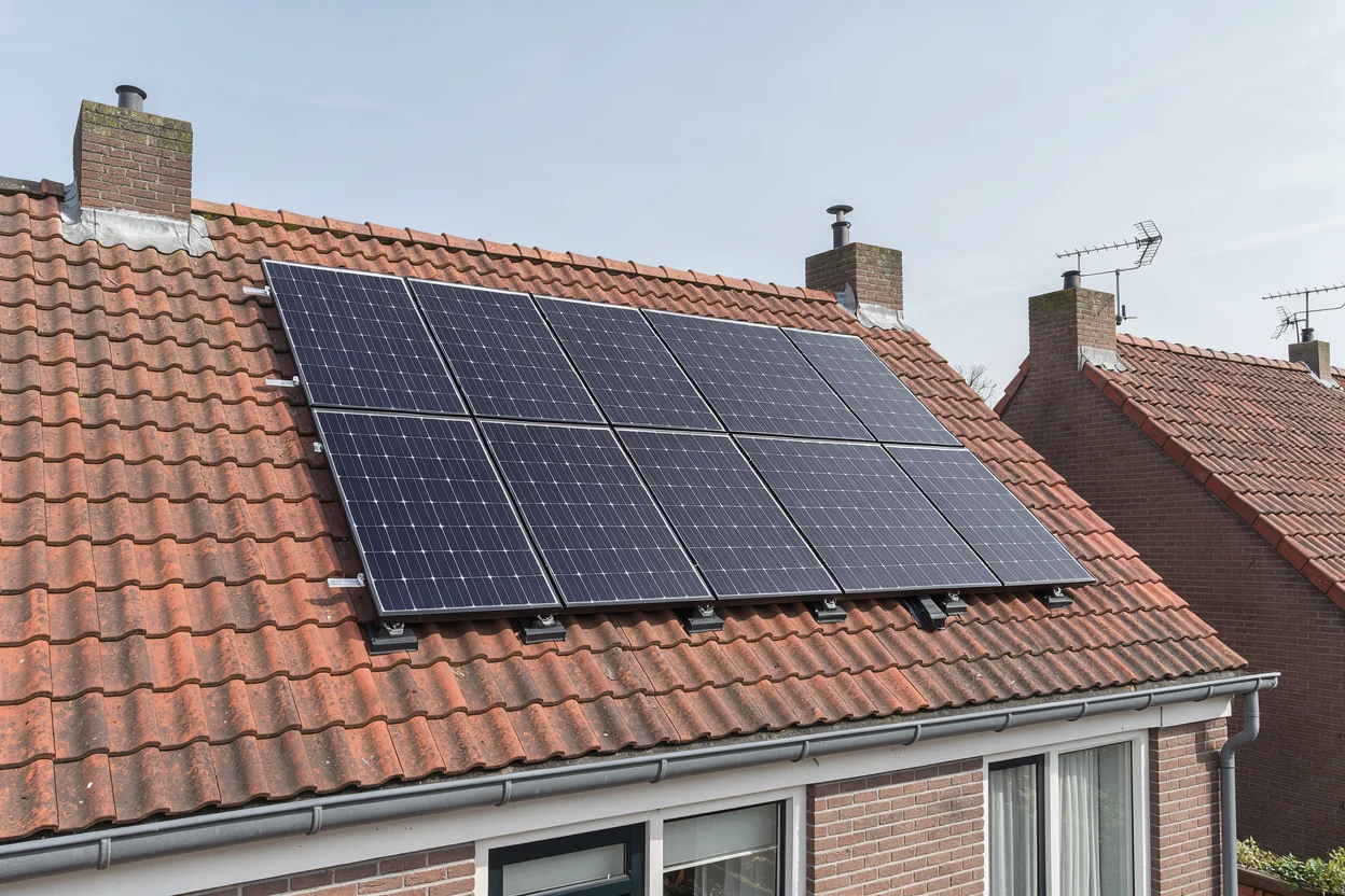Zonnepanelen op het pannendak van een rijtjeshuis bij daglicht