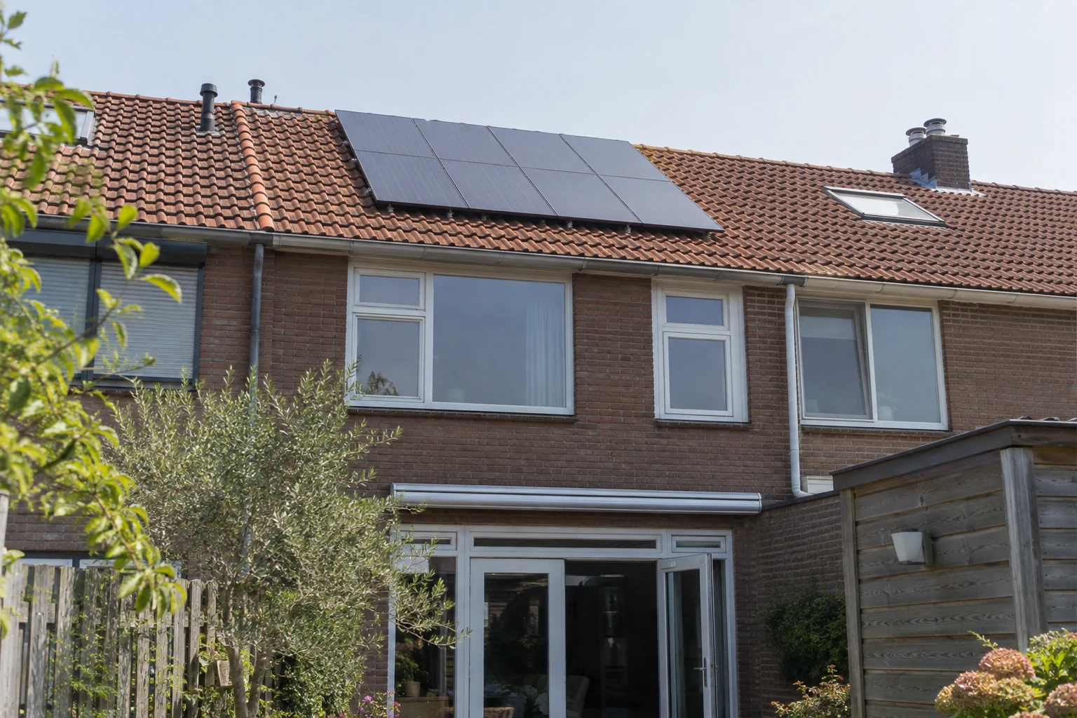 Zonnepanelen op het pannendak van een rijtjeshuis bij daglicht