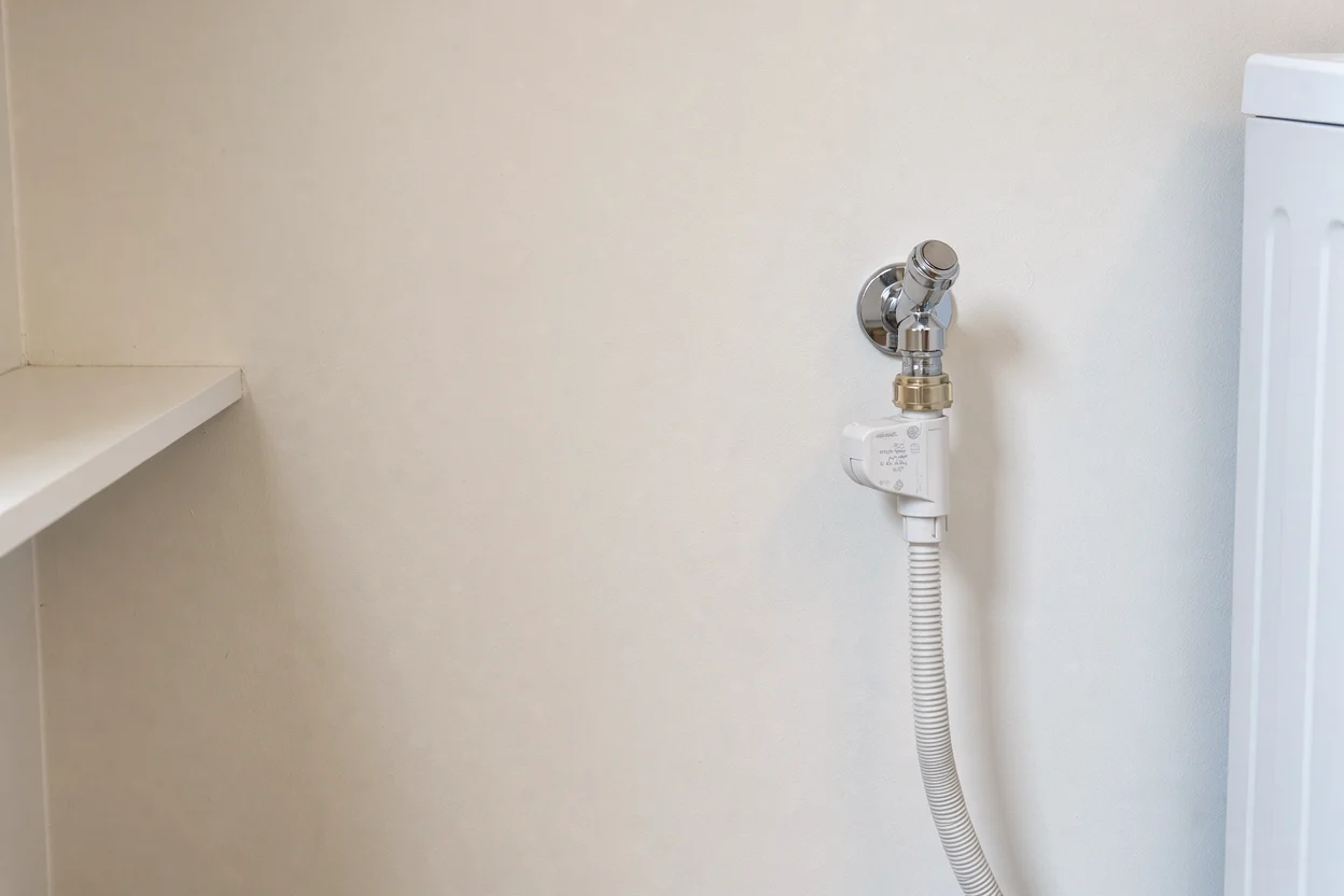 Kraan met gesloten slangverbinding op een vrij bereikbare wand