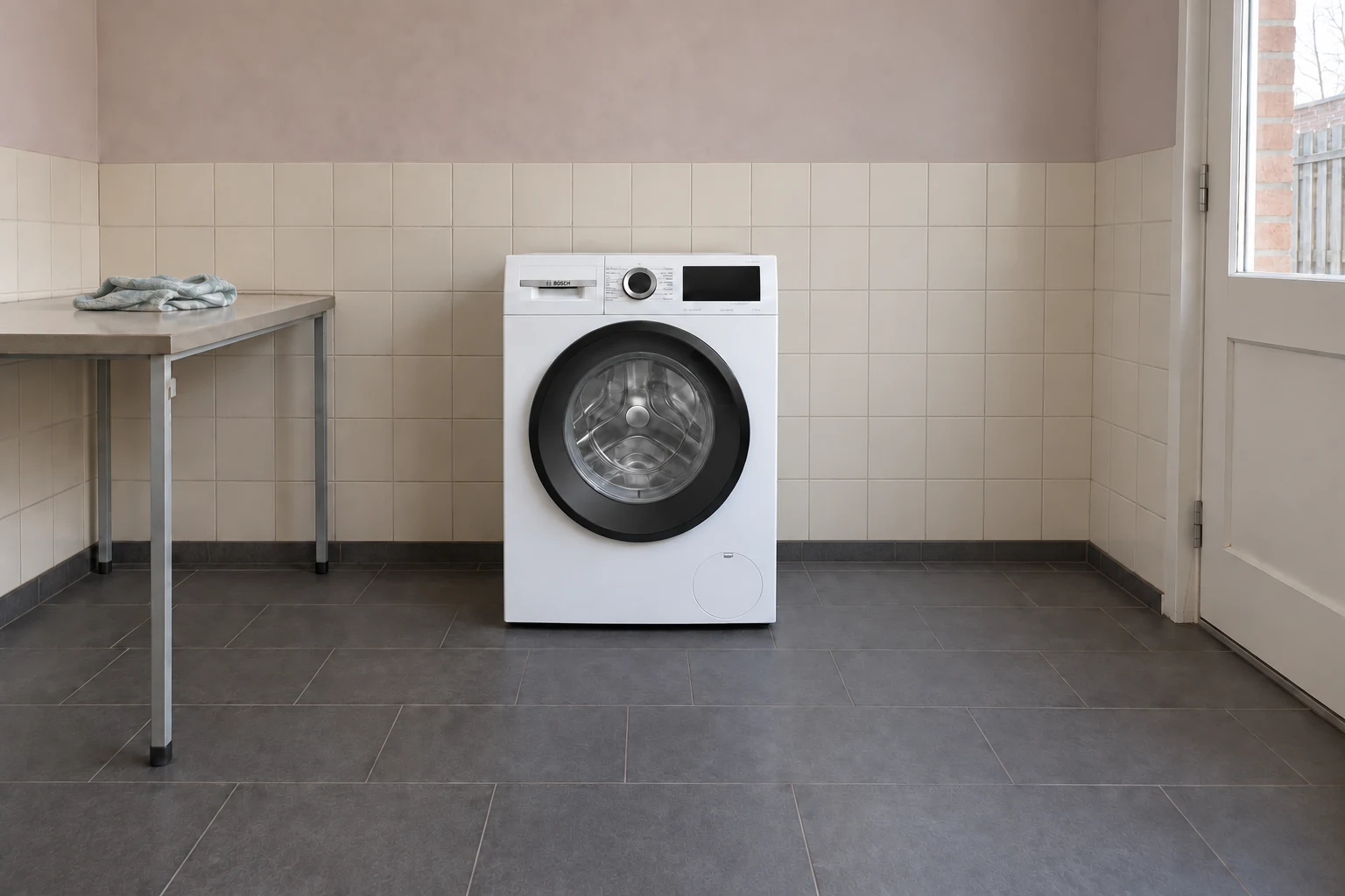 Gesloten witte wasmachine in een eenvoudige betegelde bijkeuken