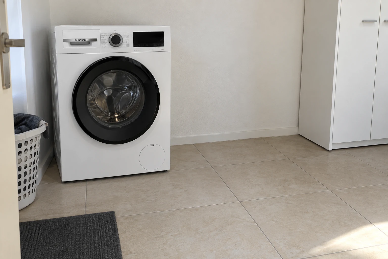 Vrije opstelruimte naast een gesloten wasmachine, met ruimte op de vloer ervoor.