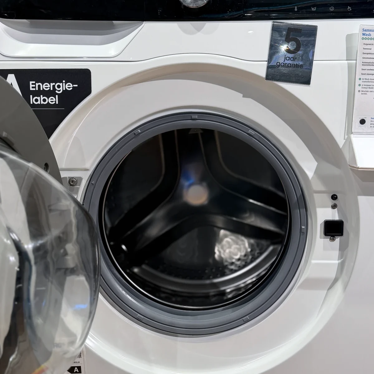 Samsung WW90DG6U85LK AI Wash met geopende deur en zicht op de trommel en rubberen deurrand.